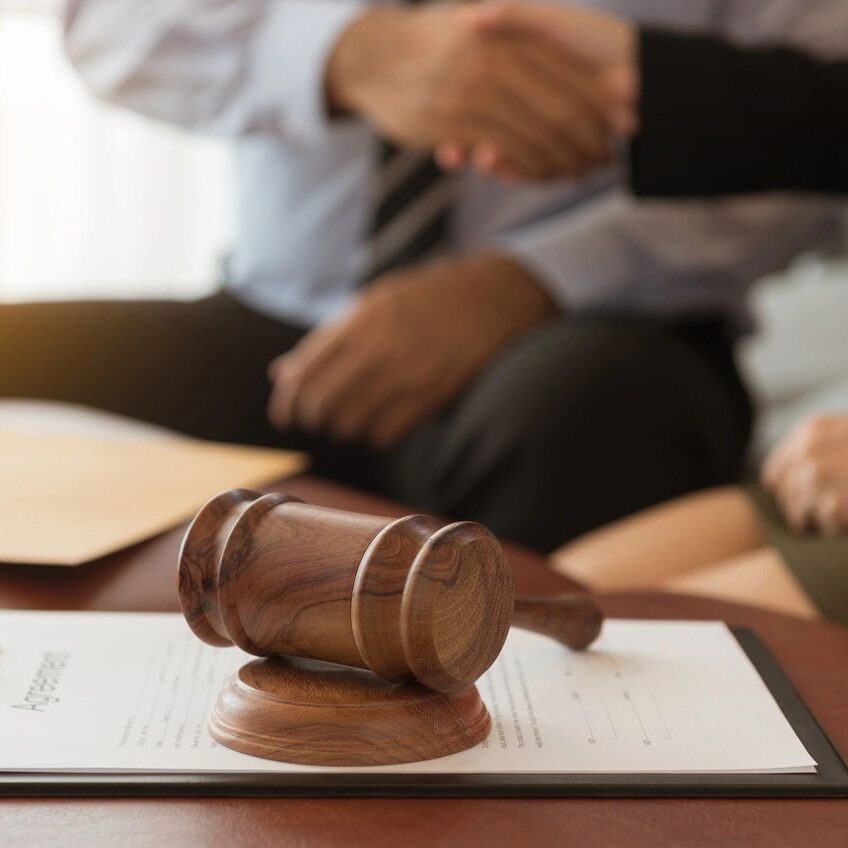 Gavel on document, people shaking hands. Gavel on document, people shaking hands.